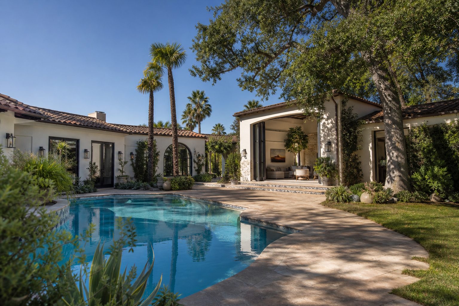 Spanish style home with tile roof and pool courtyard framed by palm trees in Woodland Hills