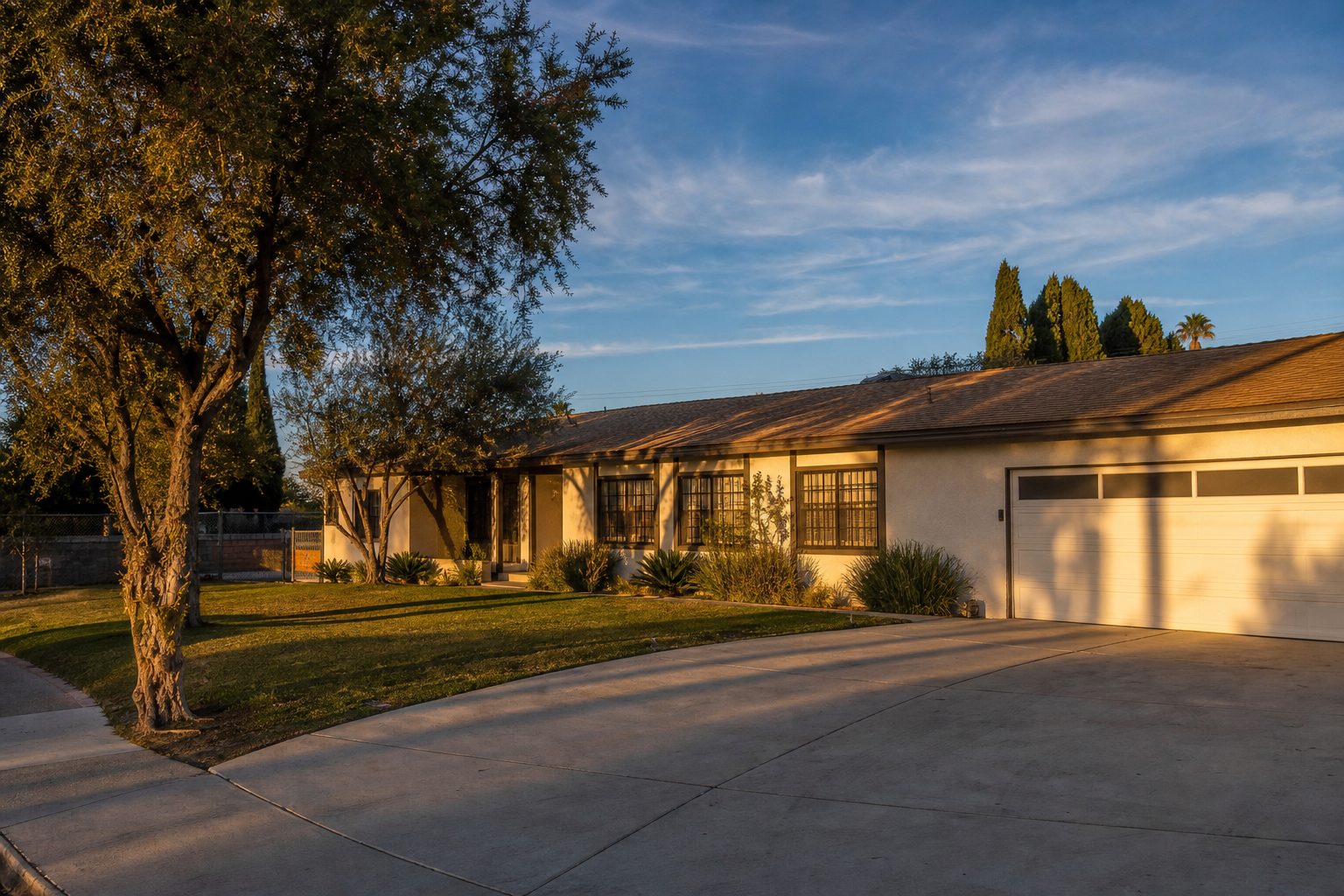 Single story ranch home with two car garage and wide driveway at golden hour in Lake Balboa