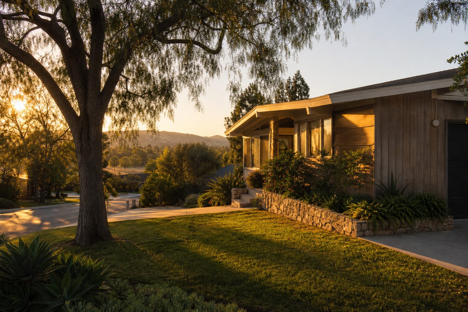 Mid-century single-family home with pepper trees and manicured lawn in Lake Balboa neighborhood, golden hour sunlight.