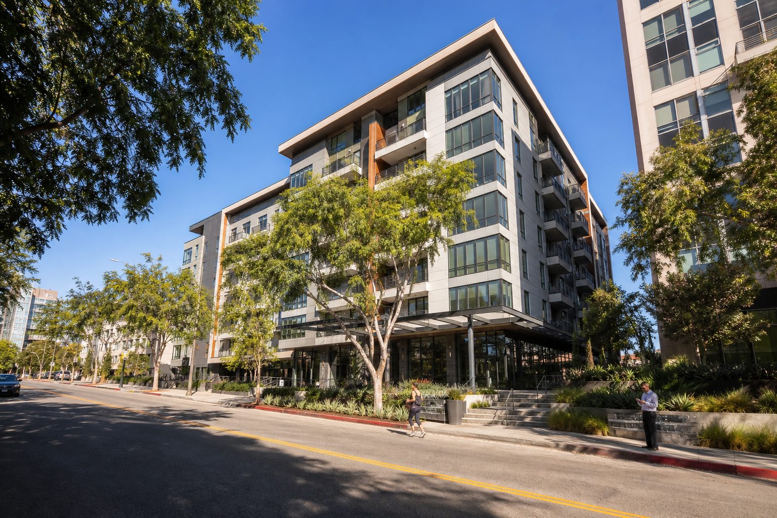 Contemporary seven-story residential building with ground-floor retail and street-level pedestrians in Warner Center Woodland Hills.