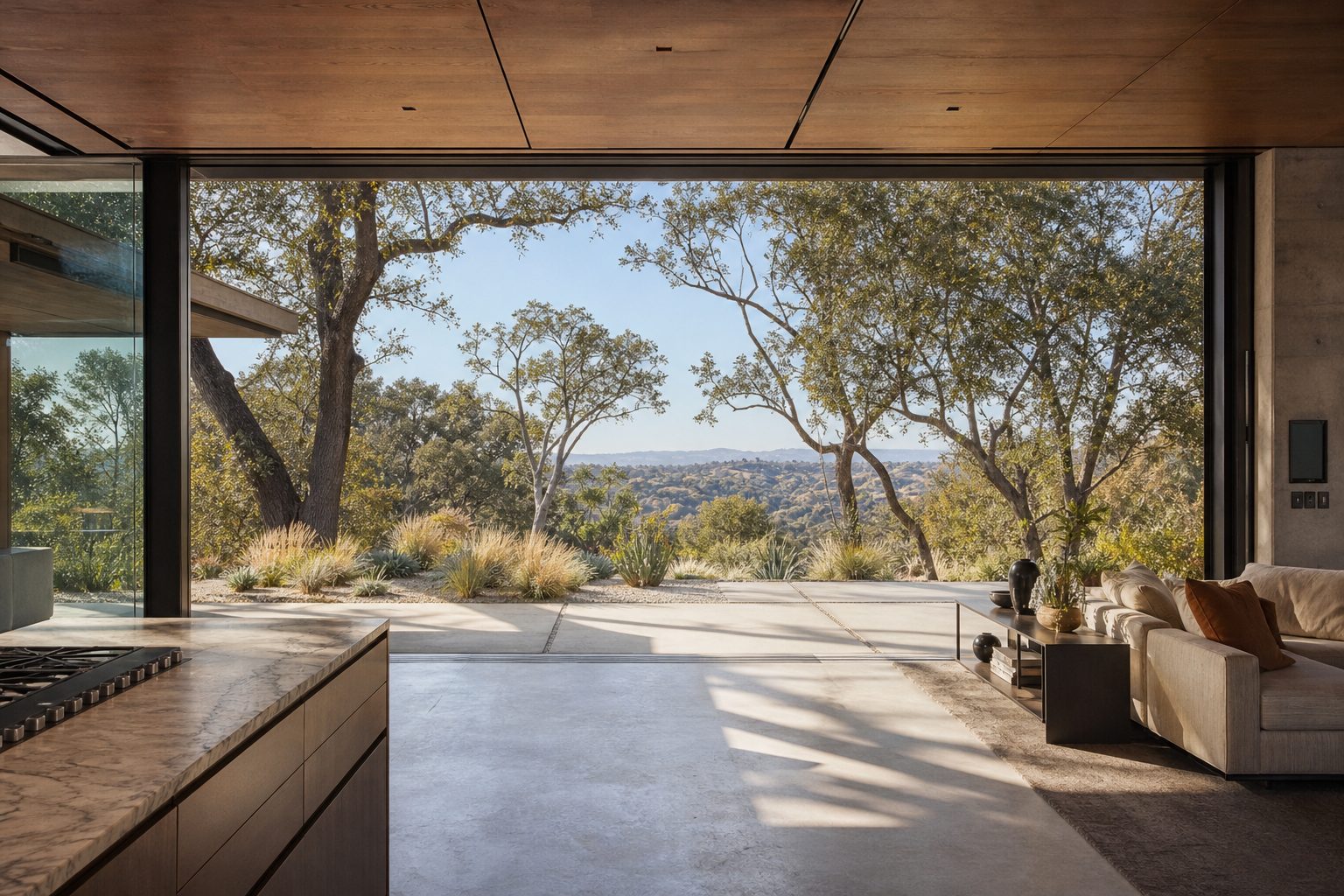 Luxury Woodland Hills home interior with seamless glass transition to mature hillside landscaping and valley views.