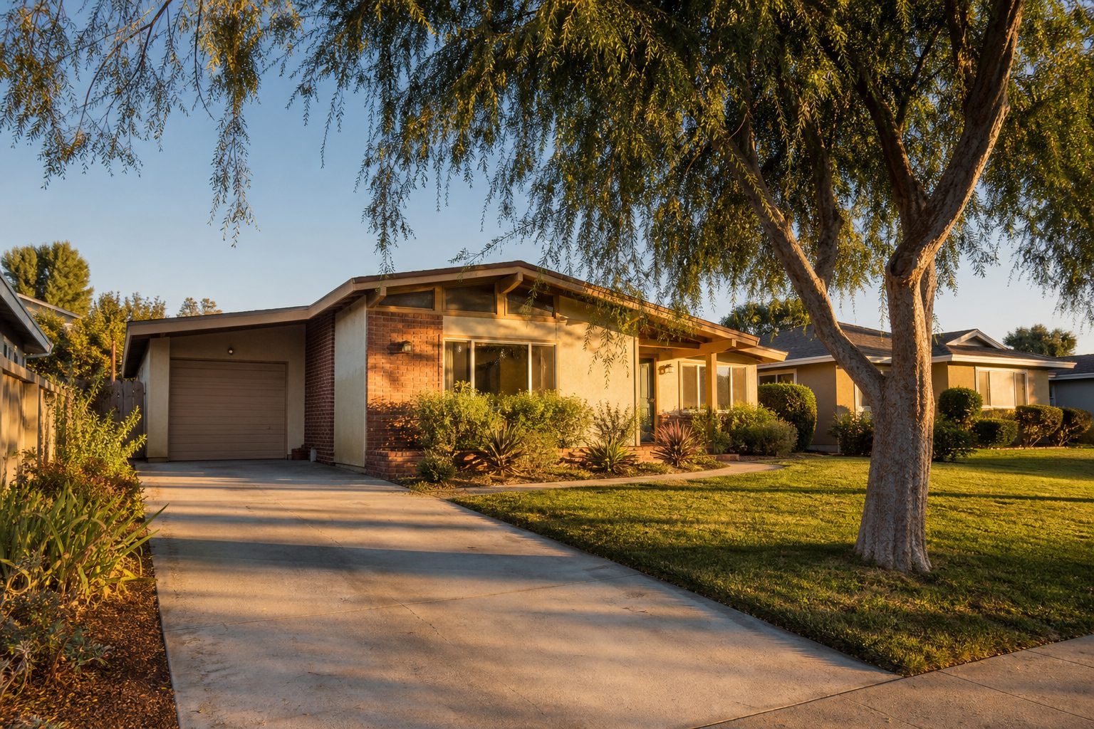1950s ranch home with pepper trees and mature landscaping in Northridge at golden hour.