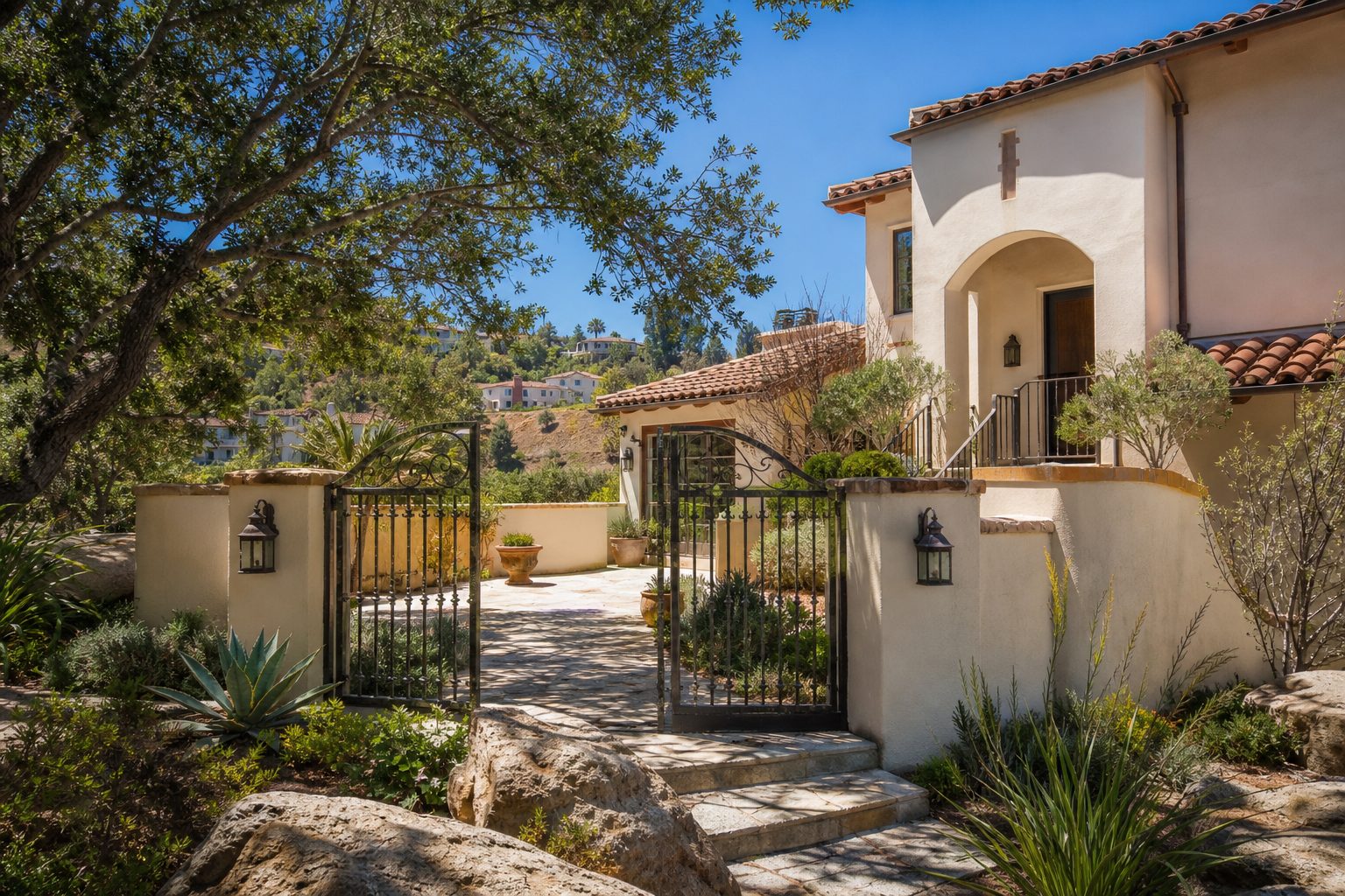 Mediterranean-style home with arched entry and native plantings in Woodland Hills hillside neighborhood.