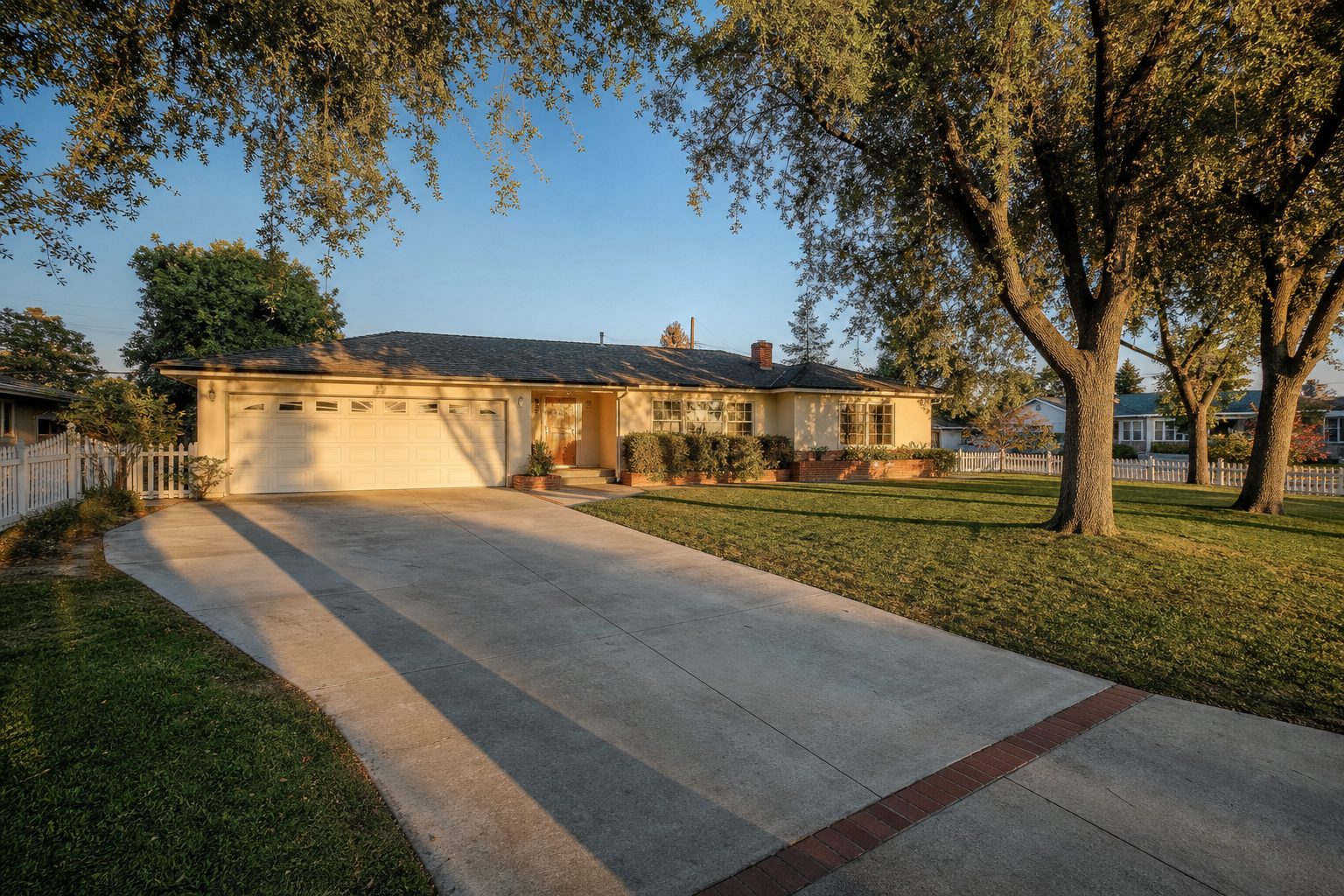 1950s cream stucco ranch home with mature shade trees and wide driveway on quiet Lake Balboa street north of Saticoy.