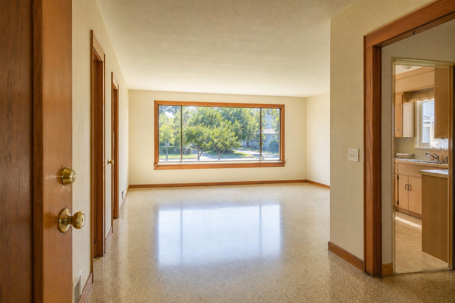 Sunlit interior of 1950s ranch home showing original wood trim, picture window, and open living room floor plan in Lake Balboa.